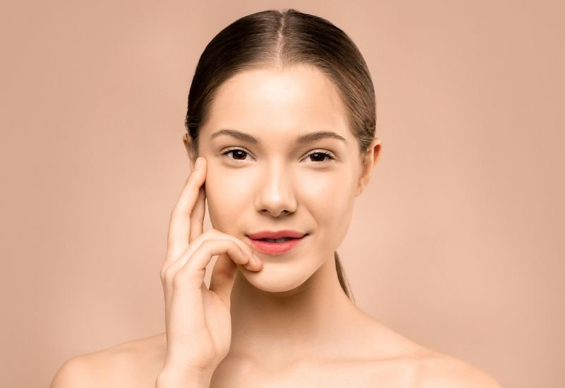 Retrato de mulher com pele radiante e viçosa, resultado de protocolo facial revitalizante